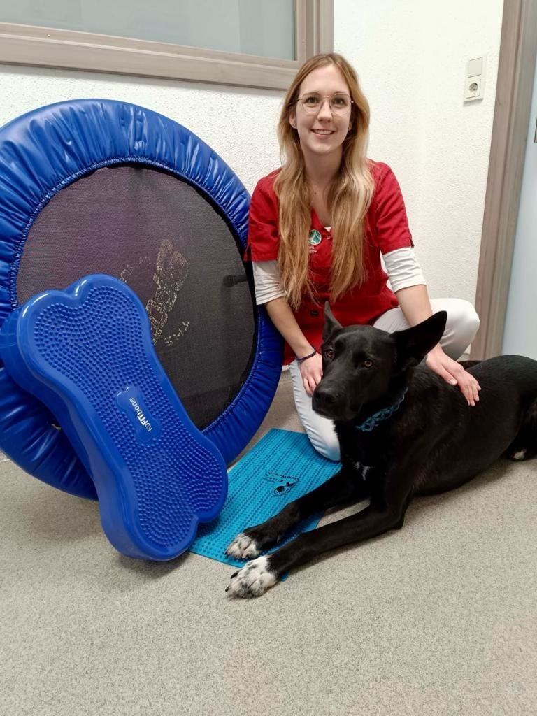 Chantal Ruppel mit einem Hund zwischen Trampolin und Balancegeräten